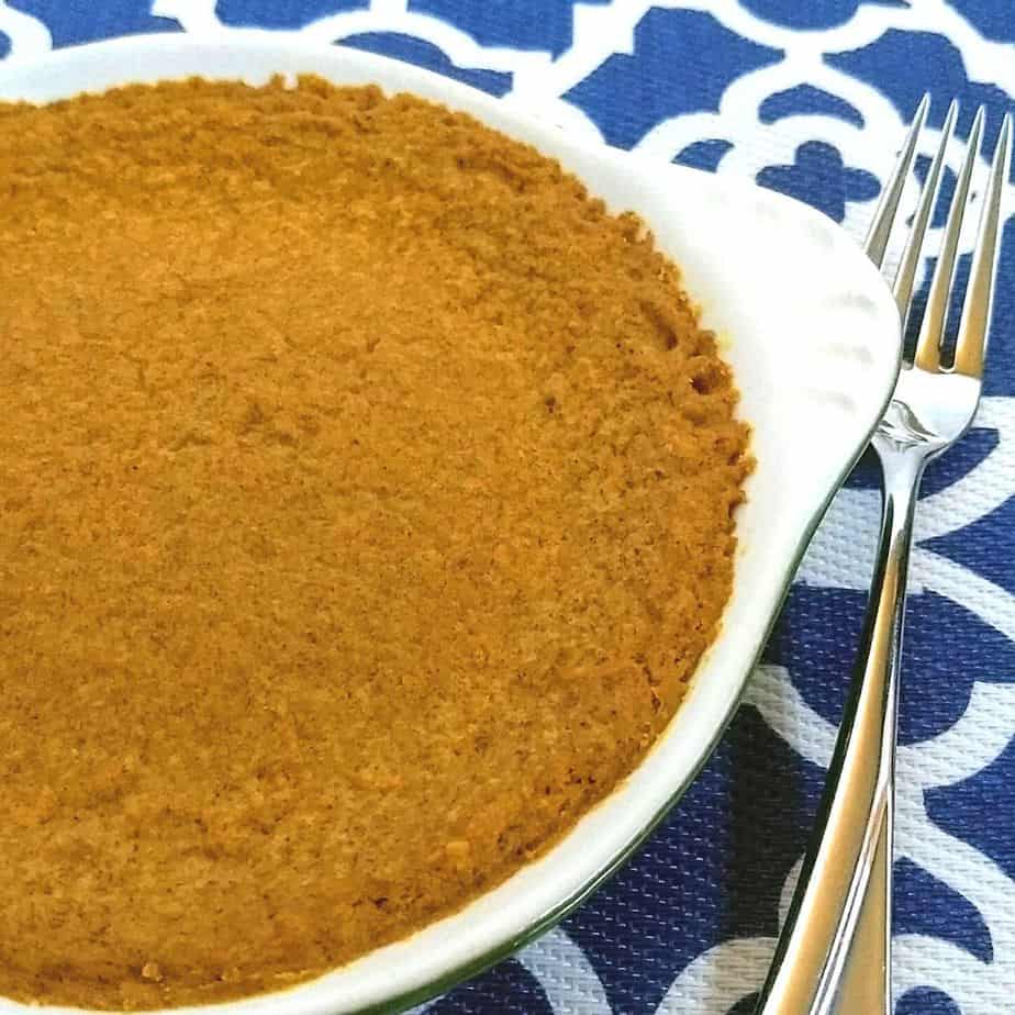 Pumpkin pie in dish with a fork on a blue and white mat - Crustless Keto Pumpkin Pie| Egg Free