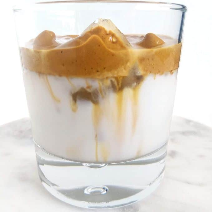 whipped coffee in a glass with ice and milk