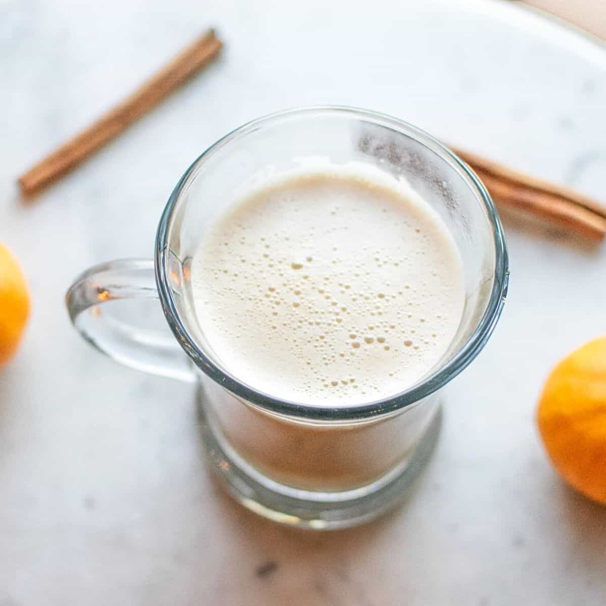 coffee in a glass with oranges and cinnamon sticks