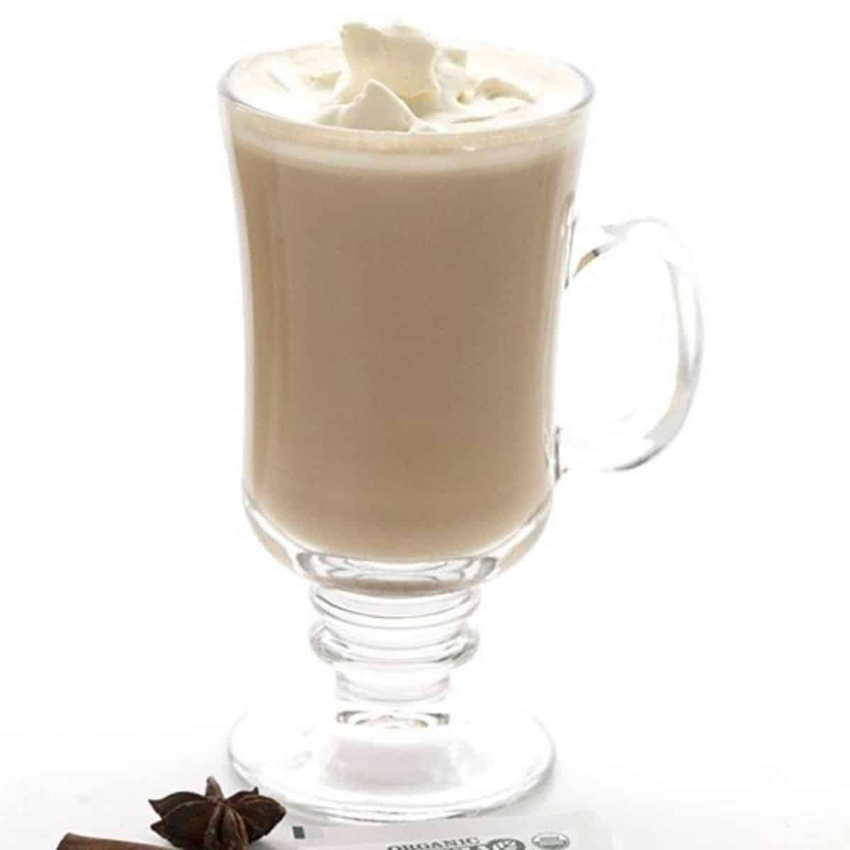 latte with whipped cream on top in a clear glass