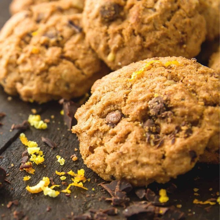 Cookies in a pile with orange zest and chocolate crumbs.