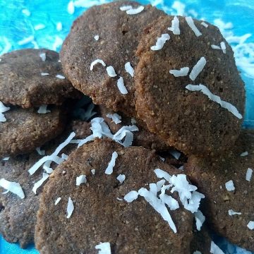 Chocolate cookies in a pile with coconut shreds on top.