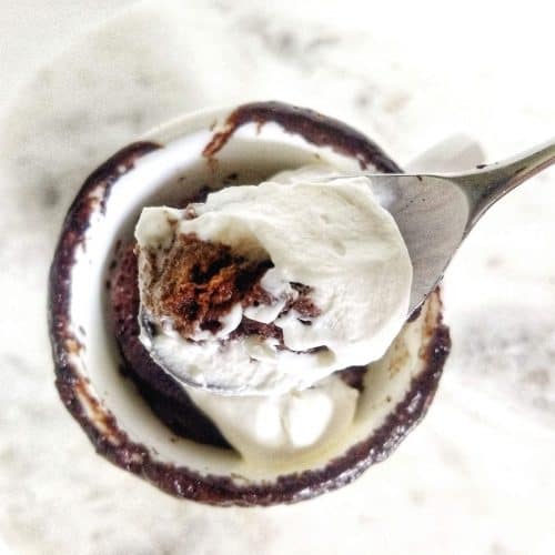 Overhead shot of low carb chocolate mug cake with heavy cream.