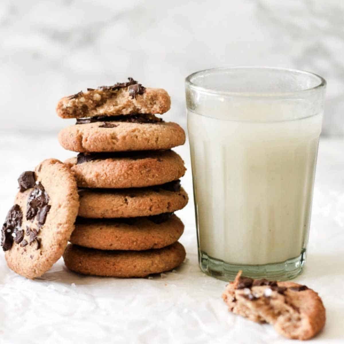 cookies stacked next to glass of milk