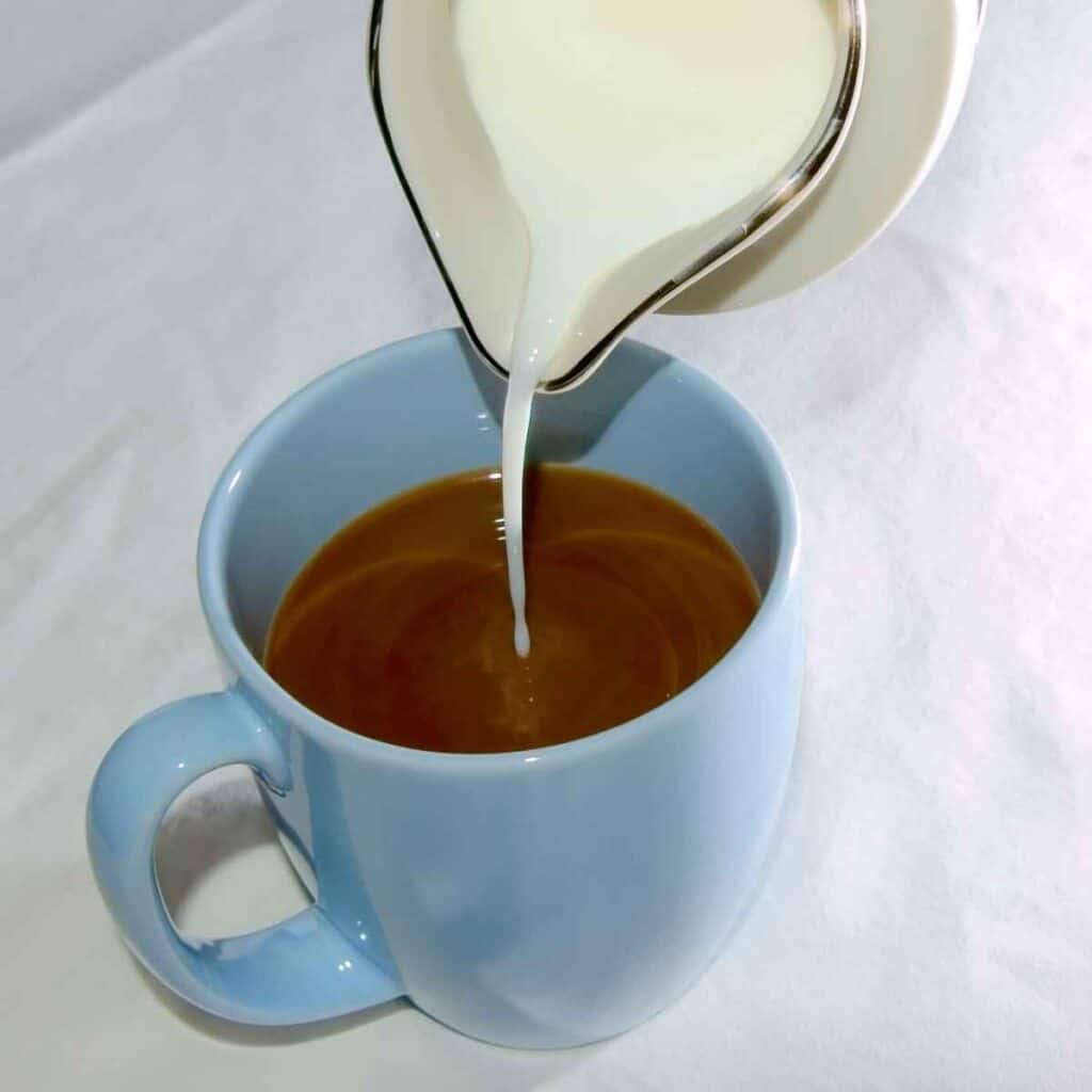 creamer being poured into coffee