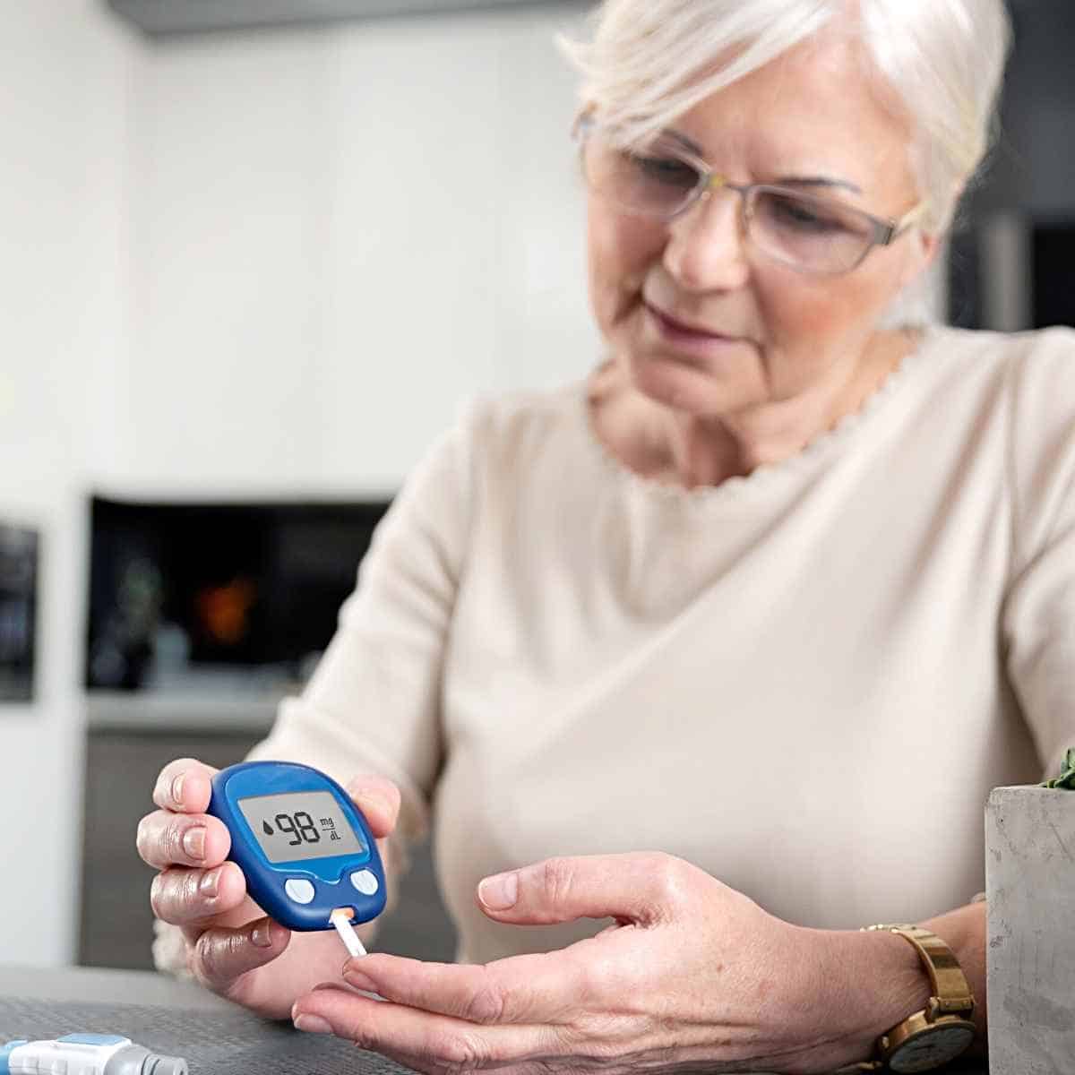 Fordeler og ulemper med Keto-dietten dame som tester blodsukkeret hennes - Fordeler og ulemper med Keto-dietten