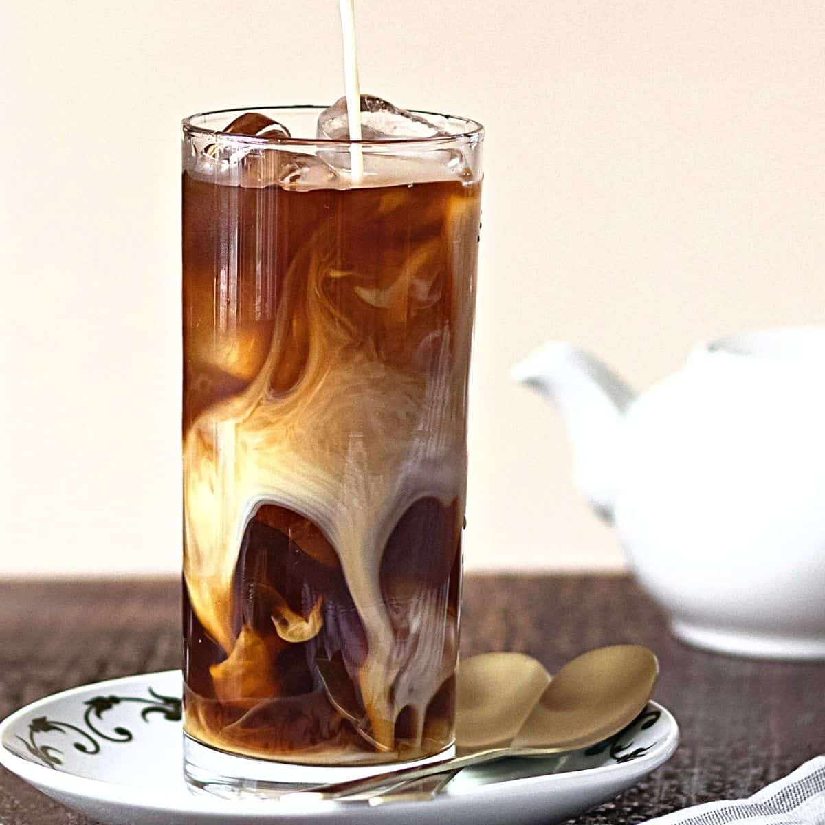 cream being poured into cold brew coffee