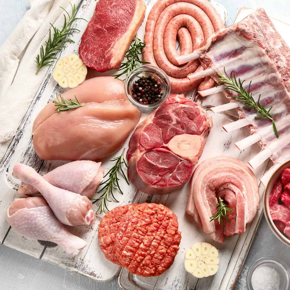 a bunch of different raw meats layed out on a board