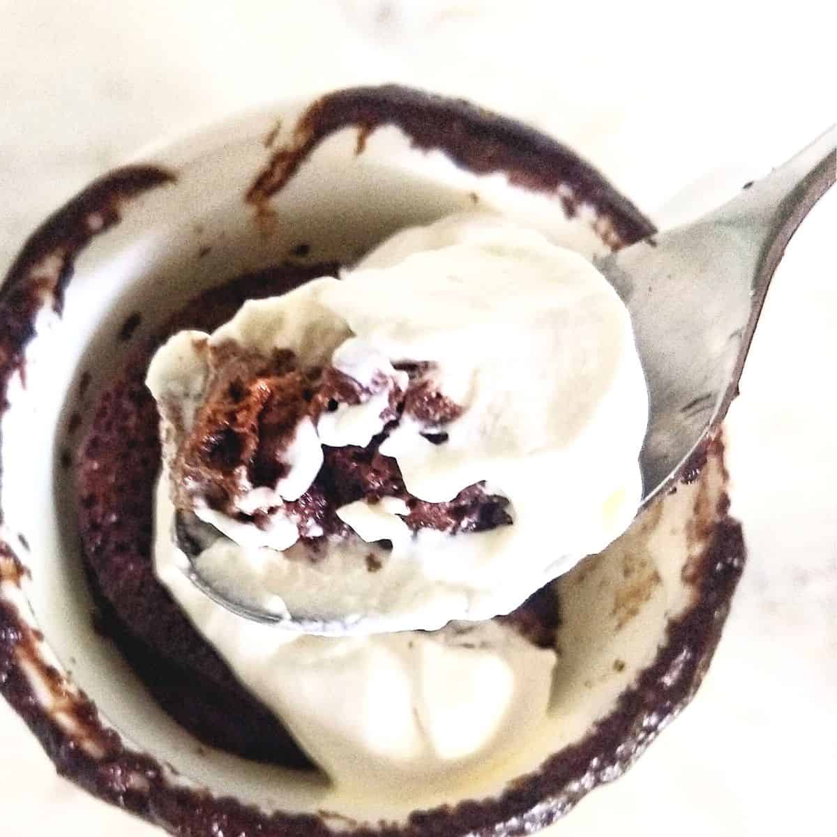 Scoop of chocolate mug cake over the mug